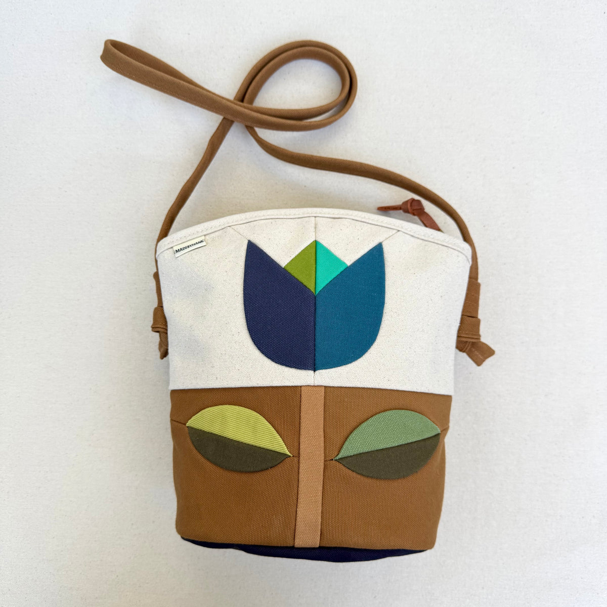 The Emmy Crossbody, pieced work tulip in natural/caramel/blues+greens