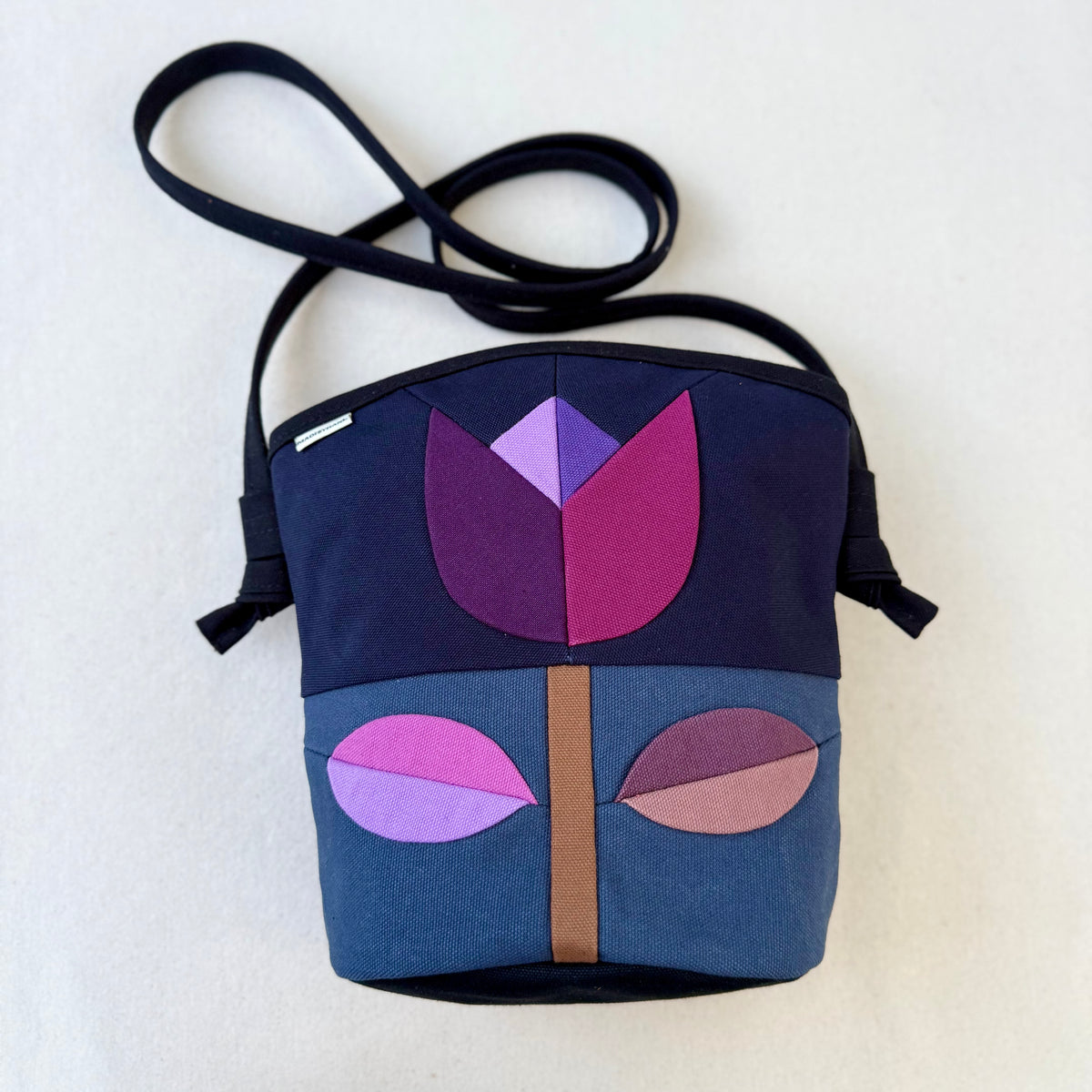 The Emmy Crossbody, pieced work tulip in midnight and dusk blue with purples+mauves