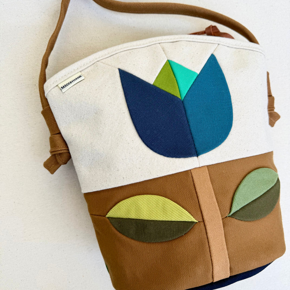 The Emmy Crossbody, pieced work tulip in natural/caramel/blues+greens